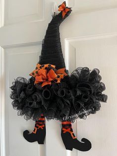 a door hanger decorated with black mesh and orange bows