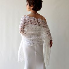 a woman wearing a white crochet shawl and dress, with her back to the camera