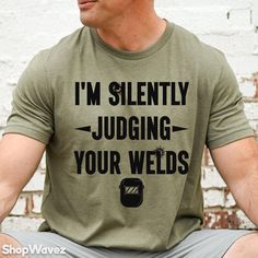 a man wearing a t - shirt that says i'm silently judging your weeds