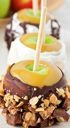 three desserts with chocolate, caramel and apple slices on the top one has a straw in it