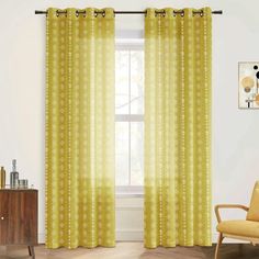 a living room with yellow curtains and a chair in front of a window that has an abstract pattern on it