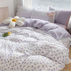 a bed with two stuffed animals on it's head and pillows in the background