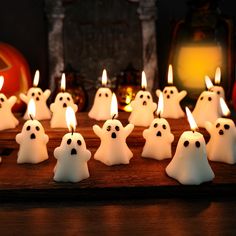 there are many white ghost candles on the table