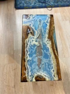 a piece of wood that is on the floor with blue and white marble in it