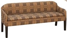 a brown and tan patterned couch sitting on top of a white floor next to a lamp