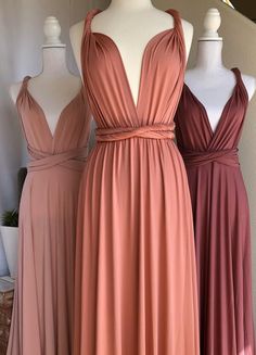 three bridesmaid dresses on mannequins, one in pink and the other in brown