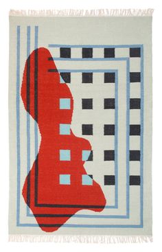 a red, black and white rug with blue squares on the bottom in front of a square