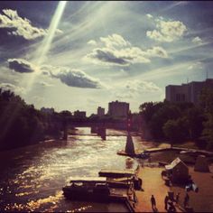 the sun shines brightly over boats on the river