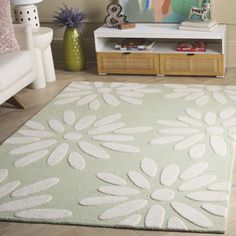 a living room with white furniture and a green rug