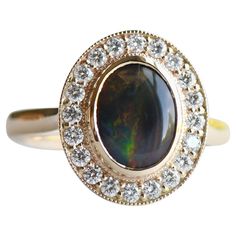 14k solid yellow gold with Australian black opal. Stone weight: 1.188 carat opal Cabochon-cut 20 - 1.6mm diamonds pavè setting on halo Bezel set 9x7 Black Australian opal center stone. Measurement: Band width 2.3mm All of our jewelry will arrive in custom packaging ready for gift giving. LEAD TIME: Made to order will take 10-14 days. FOLLOW US ON: Instagram: @roseandchoc Facebook: /Roseandchoc Pinterest: @Roseandchoc