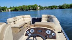 the inside of a motor boat with seats and steering wheel on the water near houses