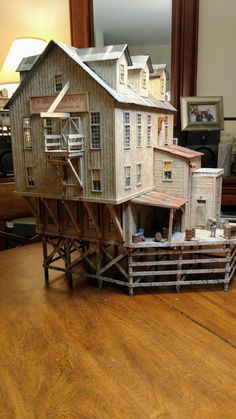 a model of a house sitting on top of a wooden table next to a mirror