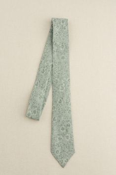 a green tie laying on top of a white surface