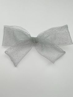 a large white bow with dots on it's side, against a gray background