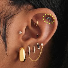 a woman with ear piercings and jewelry on her left ear, looking to the side