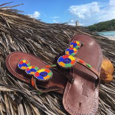 Beaded in the Maasai tradition by women Artisans receiving a fair wage, our sandals beautiful but tough - well-suited for everyday wear. Made by hand in Tanzania, each pair will have slight variations adding to its unique style. 100% of net proceeds are invested the Artisans and our innovative menstrual hygiene program, UhuruPads (East Africa's first 100% compostable sanitary pad, produced by a team of women for distribution to girls keeping them in school). Product Features: beautiful beading t Traditional Adjustable Brown Flip Flops, Traditional Brown Toe Post Flip Flops, Traditional Closed Toe Barefoot Sandals For Beach, Traditional Beaded Brown Flip Flops, Traditional Multicolor Beaded Flip Flops, Traditional Brown Beaded Flip Flops, Traditional Handmade Brown Flip Flops, Traditional Handmade Adjustable Sandals, Traditional Adjustable Toe Post Sandals