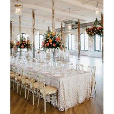 a long table with many chairs and flowers in vases on the top is set up for a formal function