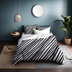 a bed with black and white striped comforter in a room next to a potted plant