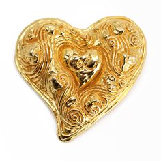 "A vintage Christian Lacroix gold toned heart shaped puffy brooch with CL signature on the front, from the 1990s. The brooch is signed Christian Lacroix CL Made in France on the back. Signed Christian Lacroix About 2.75\" x 2.75\" Vintage This item is in stock and ready to ship. It will arrive in a kraft jewelry box. I found this brooch in an estate sale. It is a used item. It does show some signs of wear consistent with its age. Please inspect photos closely. It is working and wearable. If you Vintage Gold Heart Brooches, Gold Heart-shaped Brooch For Formal Occasions, Gold Heart Brooch For Formal Occasions, Gold Heart Brooch For Formal Wear, Vintage Gold Brooches For Valentine's Day, Gold Brooches For Formal Valentine's Day, Gold Brooches For Valentine's Day Formal, Gold Brooches For Valentine's Day, Gold Heart-shaped Brooches For Gifts