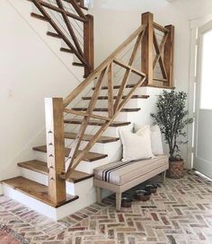 a white couch sitting under a wooden staircase