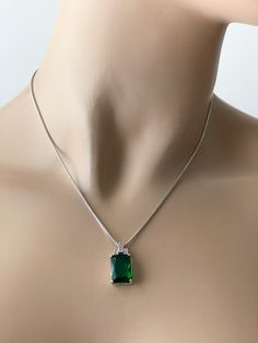 Emerald Sterling Silver Rectangular CZ Necklace. 925 Sterling Silver Stone: Green (Emerald) Pendant Height: 11 mm Pendant Width: 9 mm Emerald the Birthstone of May Epitomizes: Love, Loyalty & Faithfulness Includes a Sterling Silver Box Chain (16, 18, or 20 Inches). Formal Emerald Necklace With Rectangular Pendant, Silver Emerald Jewelry With Square Cut, Silver Emerald Square Cut Jewelry, Silver Square Cut Emerald Jewelry, Silver Emerald-cut Cubic Zirconia Necklace, Silver Emerald Jewelry With Rectangular Stone, Silver Jewelry With Rectangular Emerald, Elegant May Birthstone Necklace With Rectangular Stone, Elegant Rectangular Jewelry With Stones