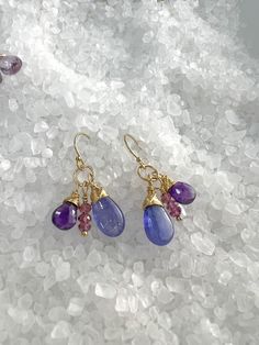 Smooth, shiny Tanzanite Briolettes, faceted dark Amethyst & faceted Rhodolite Garnets are hand wrapped and dangle from gold filled ear wires. These colors accent each other beautifully and are full of movement. Very fun, pretty earrings. Earrings measure 1 1/4" from top of the ear wires. Width approx.: 5/8". All components are gold filled. Silicon ear wires included. Purple Briolette Wire Wrapped Earrings, Dark Amethyst, Rhodolite Garnet, The Ear, Hand Wrap, Pretty Earrings, Accent Colors, Ear Wires, Gemstone Earrings