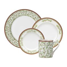 three white and green dinner plates with gold trimmings on each plate, one is empty