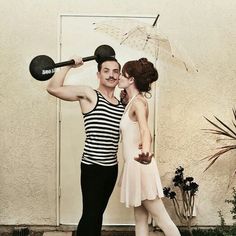 a man holding an umbrella and kissing a woman in front of a door with an umbrella