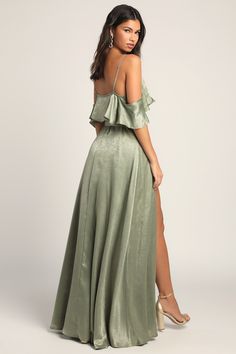 Love your look in the Lulus Moriah Sage Green Satin Wrap Maxi Dress! Soft woven satin shapes this beautiful gown with adjustable skinny straps, ruffled cold shoulder sleeves, and a surplice bodice (with modesty clasp). Adjustable waist sash creates a custom fit atop a wrap maxi skirt that flows gracefully with each step. Fit: This garment fits true to size. Length: Floor length. Size medium measures 56" from adjustable straps to hem. Bust: Works best for A to C cup sizes. Waist: Loosely Fitted. Off-shoulder Ruffled Gown For Prom, Glamorous Off-shoulder Gown With Ruffles, Elegant Maxi Dress With Ruffled Straps For Prom, Elegant Prom Maxi Dress With Ruffled Straps, Elegant Green Dress With Ruffled Straps, One Shoulder Ruffled Bridesmaid Maxi Dress, Elegant Evening Gown With Ruffled Straps, Off-shoulder Satin Maxi Dress For Prom Season, Off-shoulder Satin Maxi Dress For Prom