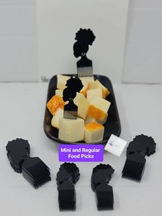 mini and regular food picks are displayed on a plate with black combs next to them