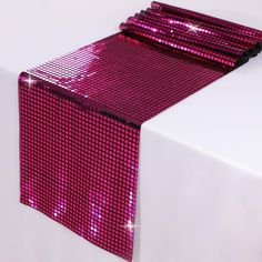 a pink table runner with sequins on it