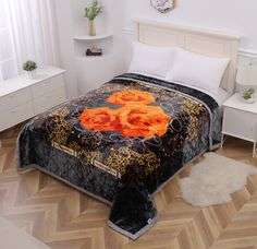 a bed with an orange rose quilt on it