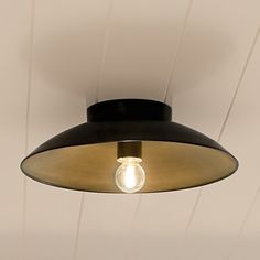 a light that is hanging from the ceiling in a room with white walls and wood paneling