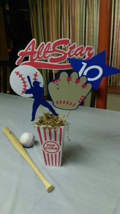 a table topped with a baseball and popcorn bucket