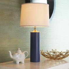 an elephant figurine next to a lamp on a table