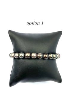 Beautiful leather Tahitian pearl beaded bracelet that is adjustable - Below are the measurements of each bracelet - Option 1 pearl size: 7.70mm - 8.05mm Option 2 pearl size: 7.05mm - 8.10mm Option 3 pearl size: 7.70mm - 7.85mm Option 4 pearl size: 7.50mm - 7.85mm Option 5 pearl size: 7.00mm - 7.95mm - Option 1 # of pearls: 23 Option 2 # of pearls: 22 Option 3 # of pearls: 24 Option 4 # of pearls: 24 Option 5 # of pearls: 22 - Option 1: 7.5 inches long Option 2: 7.5 inches long Option 3: 7.5 inch Adjustable Single Strand Pearl Bracelet, Adjustable Luxury Pearl Bracelet, Luxury Adjustable Round Pearl Bracelet, Formal Adjustable Single Strand Pearl Bracelet, Formal Adjustable Single Strand Beaded Bracelets, Adjustable Single Strand Beaded Bracelet For Formal, Tahitian Pearl Bracelet, Pearl Beaded Bracelet, Pearl Jewelry Design