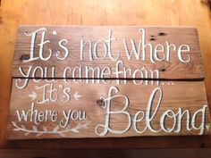 a wooden sign that says it's not where you came from, it's where you belong