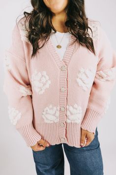 Stay cozy and stylish in this PLUS SIZE - Made You Look Sweater! With a baby pink v-neck knit cardigan, jeweled front button closure, and a white tufted floral print, you'll be looking fabulously glam. Get ready to hear lots of "Oohs" and "Ahhs!" Details V neckline Jeweled buttons Ribbed neckline, cuffs, and hemline Tufted floral print Scallop edging Sizing *Measurements are taken unstretched with item hanging* Approximate measurements: SIZE LENGTH BUST 1XL/2XL 27” 52” 2XL/3XL 29” 56” Fabric has Pink V-neck Cardigan For Loungewear, Pink V-neck Winter Outerwear, Pink V-neck Winter Cardigan, Cozy Pink V-neck Outerwear, Cute Winter Loungewear Cardigan, Pink Cardigan For Fall Loungewear, Pink V-neck Outerwear For Spring, Spring Button-up Cardigan For Loungewear, Button-up Cardigan For Spring Loungewear