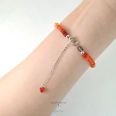 This handmade bracelet blazes with the fiery glow of Mexican fire opal. Vibrant orange beads in varying shades graduate from light to dark, creating an ombre effect that's as eye-catching as it is stylish. The smooth tyre-shaped fire opal gemstones at AAA grade bring a natural beauty to complement your everyday wardrobe. A 925 sterling silver adjustable chain ensures a perfect, comfortable fit. Fire opal's shimmering play of color adds a touch of magic to any ensemble, while handmade craftsmansh Orange Carnelian Round Beaded Bracelets, Orange Round Carnelian Beaded Bracelets, Handmade Silver Carnelian Beaded Bracelets, Orange Carnelian Hand-strung Bracelets, Orange Sterling Silver Jewelry With Round Beads, Orange Hand-strung Carnelian Bracelets, Elegant Orange Bracelets With Faceted Beads, Orange Faceted Beads Bracelet As Gift, Handmade Orange Carnelian Beaded Bracelets