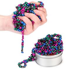 a tin can filled with colorful beads and a person's hand reaching for it