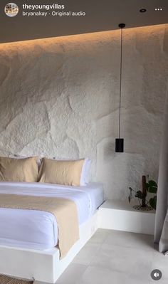 there is a bed that has been made in the room with white walls and beige linens