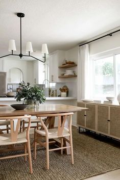 a dining room table and chairs in front of a window