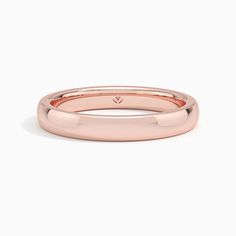 a rose gold wedding ring on a white background