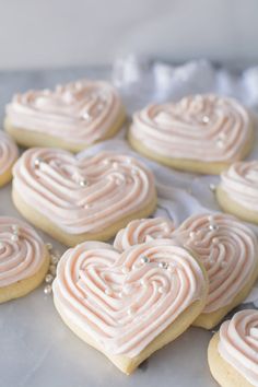 heart shaped cookies with frosting sitting on a table