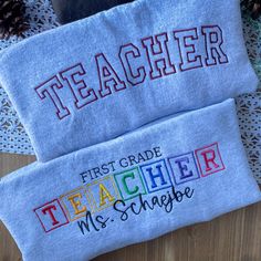 two personalized teacher's towels on a doily with pine cones in the background