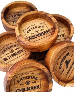 six wooden coasters with the names of different towns and cities on them, all engraved in wood