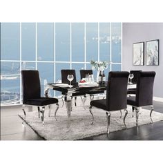 a glass dining table with black chairs and white rug