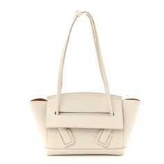 This is an authentic BOTTEGA VENETA Grainy Calfskin Small Arco in Plaster. This stylish shoulder bag is crafted of white grained calfskin leather. The bag features a basket shape, with smooth looping leather shoulder straps, and gold hardware. The front flap opens to a brown suede leather interior with a hanging zipper pocket. Cream Calf Leather Bags With Palladium Hardware, Formal White Calf Leather Shoulder Bag, Designer White Calf Leather Bag, Designer White Calf Leather Shoulder Bag, Cream Shoulder Bag With Palladium Hardware For Office, Elegant White Calf Leather Shoulder Bag, Luxury White Calf Leather Bag, Elegant Cream Calf Leather Shoulder Bag, Luxury White Calf Leather Shoulder Bag