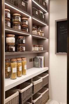 an organized pantry with lots of food in baskets and jars on the shelves next to a chalkboard