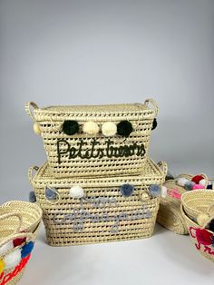 three woven baskets with pom - poms on them